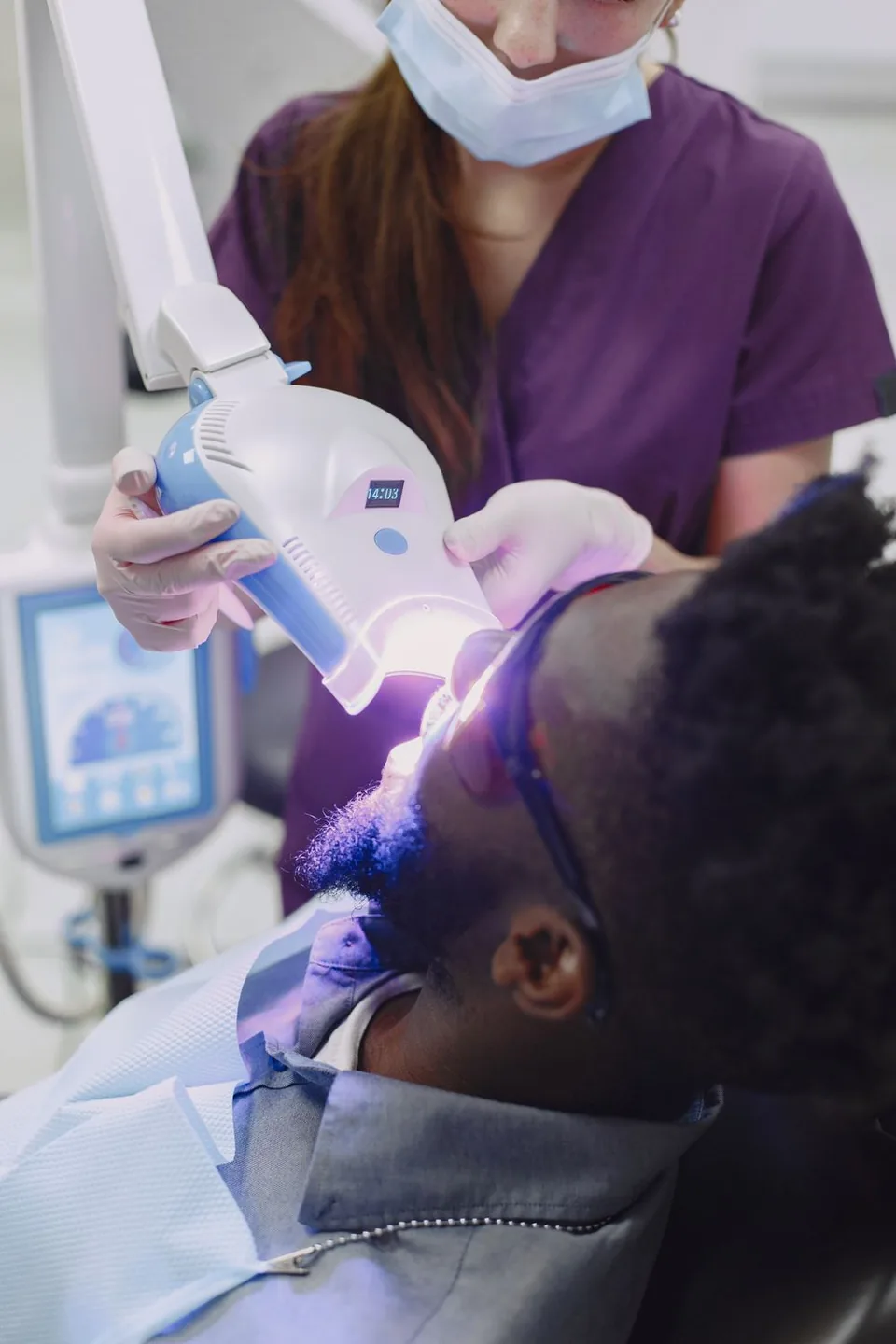 Illustrative stock photograph of a patient receiving treatment under a teeth-whitening lamp